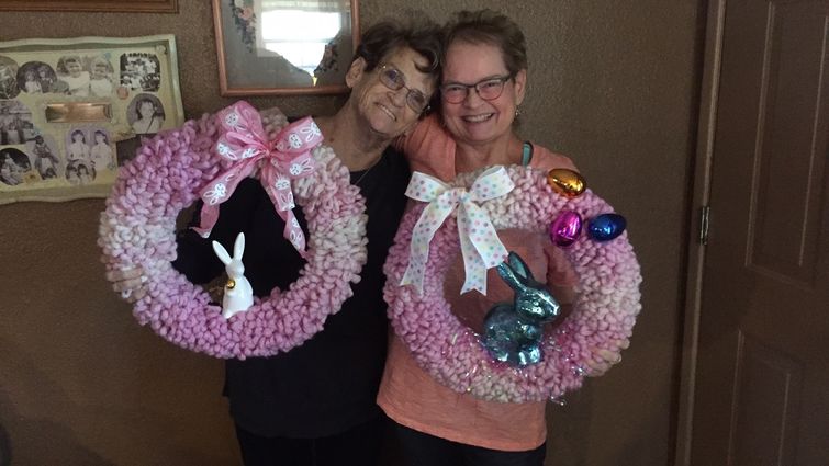 Two women holding easter wreaths