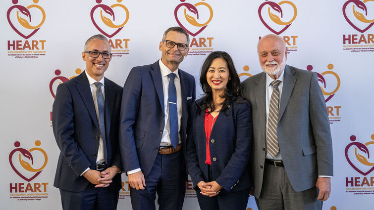 From left, Daniel Dawes, Anthony Hilliard, Helen Tran and Richard Hart standing in front of a backdrop showcasing the HEART initiative graphic