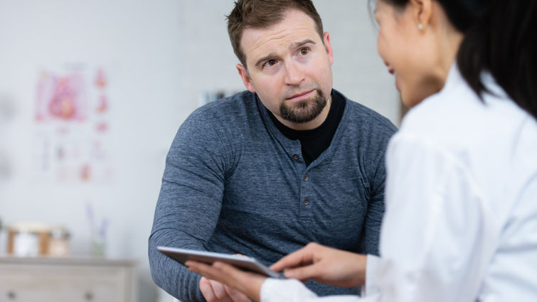 man sitting with a doctor