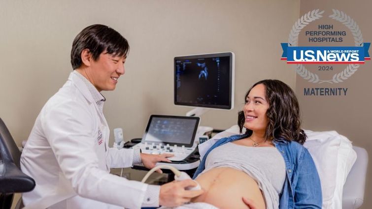 Caucasian woman with brown hair receives a prenatal ultrasound from a doctor of Asian decent