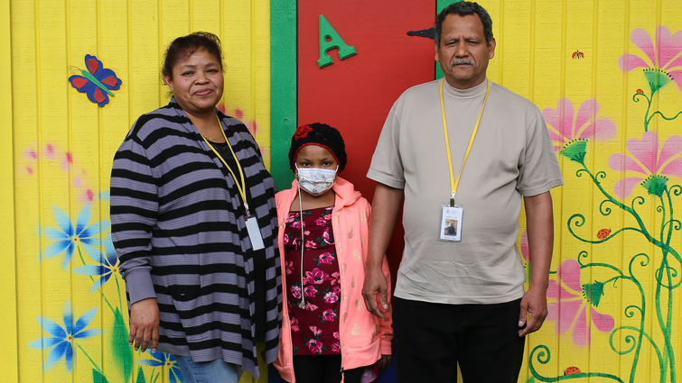 hispanic female pediatric patient poses for photo with her mother and father