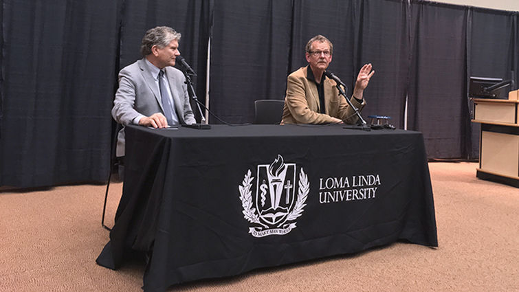 Professor of Religion James Walters, PhD, left, and guest speaker Philip Clayton, PhD, took questions from the audience after Clayton’s plenary address during the conference “What’s with Free Will? Ethics and Religion after Neuroscience.” Two men sit at table with microphones
