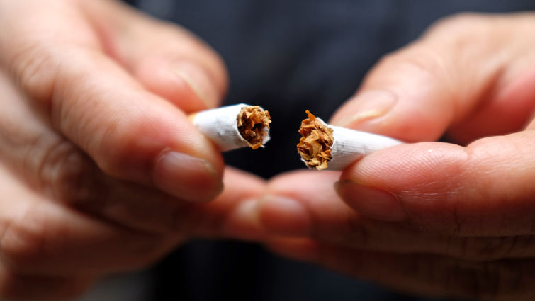 man holding broken cigarette