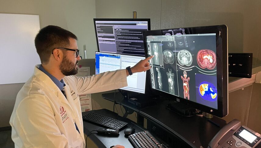A man is looking at a computer screen of a human body scan 