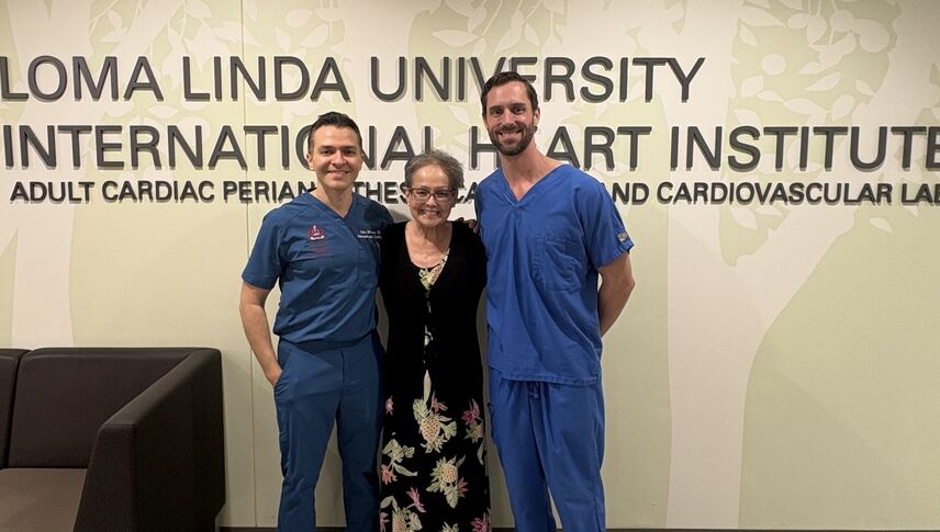 a woman poses with two men beside her all smiling 