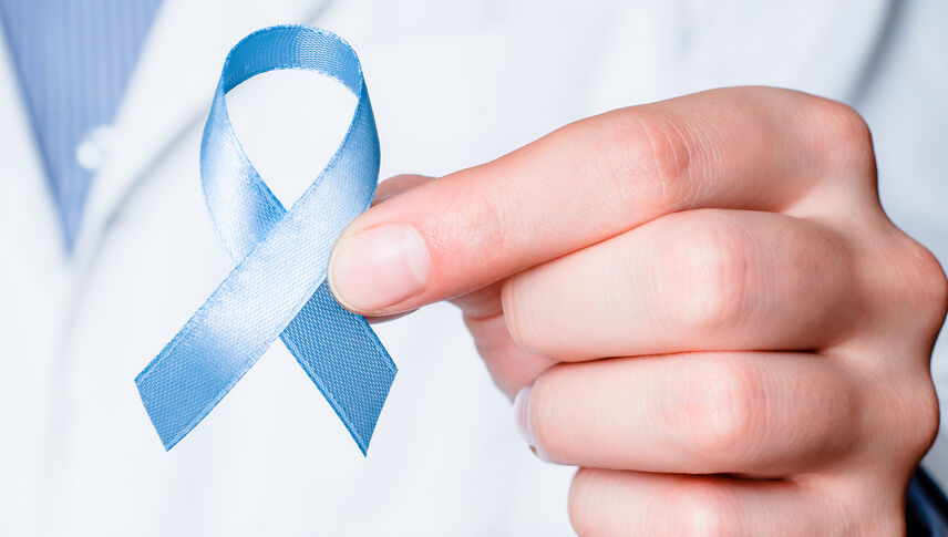 Blue ribbon in doctor hand.