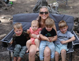 Lynn Olsen sitting with four small grandchildren