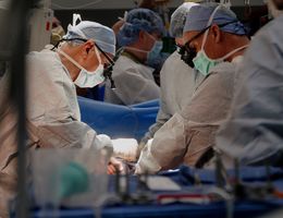 Three doctors operating on 12-year-old patient