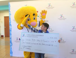 Ulysses Hsu high fives the Children’s Hospital mascot, Luke the Lion