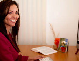 Woman smiles at her desk