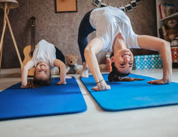 mom and daughter do yoga at home