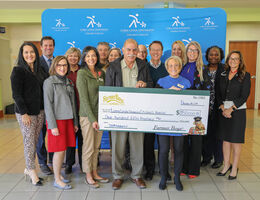 group of representatives stand with $150,000 check