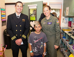 male and female pilot pose for photo with young male patient