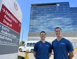 Two men stand in front of a medical building