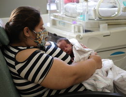 mother sits in the nicu with her small baby