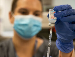 A Loma Linda University Health employee prepares to administer a COVID-19 vaccine. 