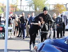 mother and son seeing new car for first time, smiling and emotional
