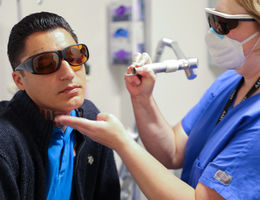 Dr. Burruss uses a laser to remove a tattoo on David Loya's face.