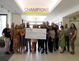 Corky's and Loma Linda University Children's Hospital staff stand together, all smiles, during a check presentation supporting the hospital's mission to provide exceptional care to young patients.