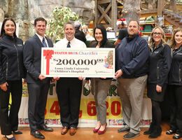 group of representatives stand with $200,000 check