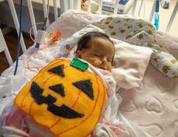 female infant with felt pumpkin costume