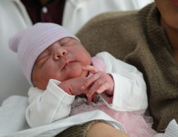 close up of baby girl wearing pink hat and tutu