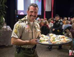 police officer holding tray of food for guests