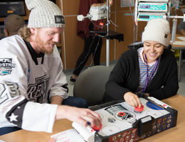 hockey player plays air hockey with teenage female patient