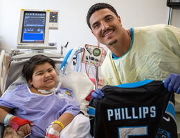 Phillips poses with a young patient