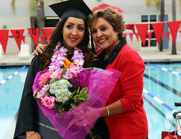 A graduate poses with a loved one after the commencement ceremony for School of Allied Health Professions.