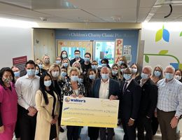 Group of people in a hospital hallway during a check presentation