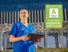 Nurse standing smiling outside of the hospital