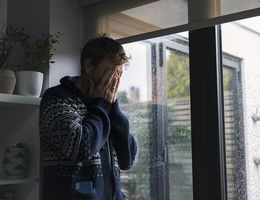 Man by window - head in hands - stock photo