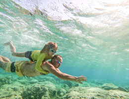 dad and daughter swimming under water