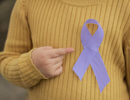 An epilepsy awareness ribbon pinned to child's sweater