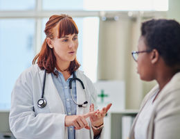 Shot of a doctor having a consultation with a young woman - stock photo