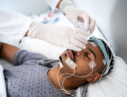 Doctor preparing patient in bed for polysomnography (sleep study) - stock photo