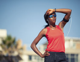 female runner shading herself from the sun