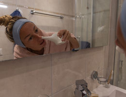 Woman using a natural nasal saline irrigation to clean her nose. Neti pot - stock photo