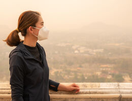 Asian woman wearing an N95 mask for protect bad air pollution. - stock photo