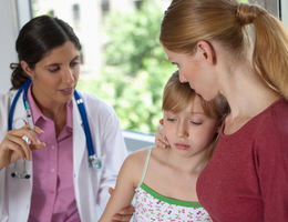 Doctor about to give young scared patient an injection - stock photo