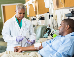 Senior phlebotomist checking on patient before taking blood sample