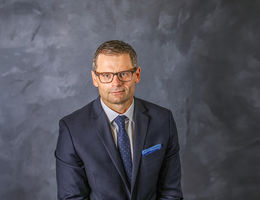 Caucasian man business headshot in suit and tie wearing glasses