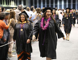 Two graduates from the School of Allied Health Professions walk down the aisle during their commencement ceremony