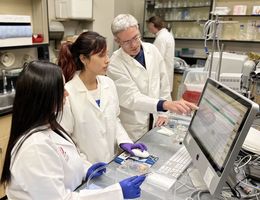 Dr. Arlin Blood conducts research with two students. Dr. Arlin Blood conducts research with two students.