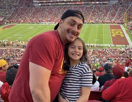 Desena watches a football game with his daughter at his alum USC