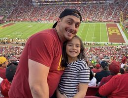 Desena watches a football game with his daughter at his alum USC