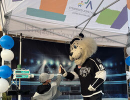 A patient high-fives mascot Kingston during the Ontario Reign hockey team's December 14 visit to Loma Linda University Pediatric Specialty Team clinics.
