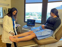 Pooja Swamy, MD, an interventional cardiologist and vascular specialist at Loma Linda University International Heart Institute, performs a vascular ultrasound on a woman’s leg.