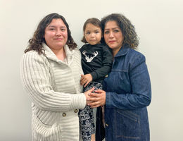 Estefania Morales (left), Giselle Morales (middle), Isabel Graciano (right) hispanic young mom embraces her mom and young daughter while standing together